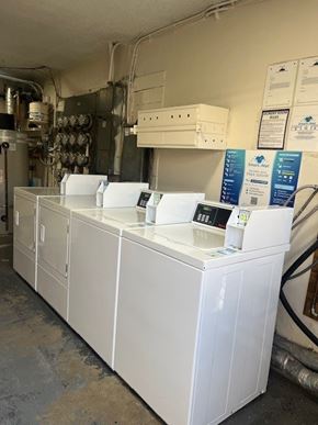 Los Angeles apartment for rent - A series of white industrial machines are lined up in a room.