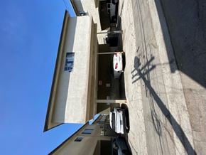 Los Angeles apartment for rent - A car is parked on the street in front of a building.
