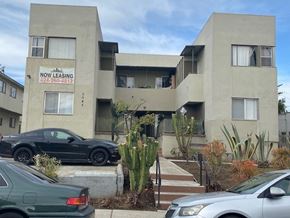 Los Angeles apartment for rent - A building with a sign that says "NOW LEASING" is surrounded by parked cars.