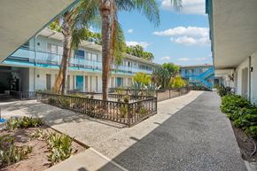 Los Angeles apartment for rent - A sunny day at a residential area with a pathway and palm trees.