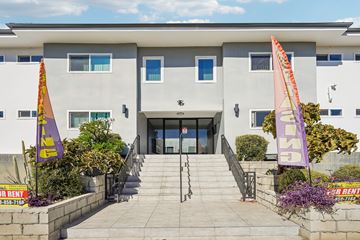 Van Nuys apartment for rent - A building with a grey facade and a staircase leading to the entrance.