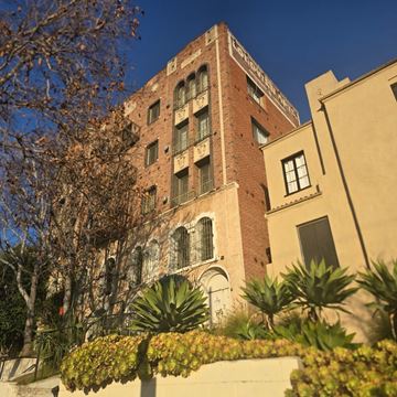 Los Angeles apartment for rent - A tall red brick building with a balcony on the second floor.