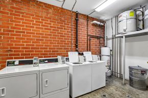 Los Angeles apartment for rent - A room with a red brick wall and a white tank.