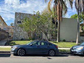 Los Angeles apartment for rent - A silver car is parked on the side of a street.
