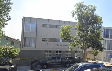 Los Angeles apartment for rent - A building with the word "TRIANON" on it is surrounded by trees and parked cars.