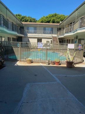 Los Angeles apartment for rent - A pool surrounded by a fence and a building in the background.