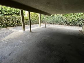 Beverly Hills apartment for rent - A parking area with a concrete floor and a hedge in the background.