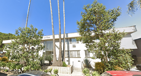 Los Angeles apartment for rent - A white building with a red car parked in front.