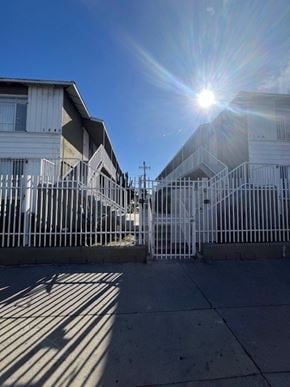 Los Angeles apartment for rent - A sunny day in front of a row of houses with a bright sun in the sky.