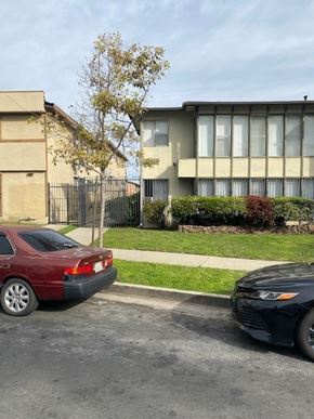 Los Angeles apartment for rent - A red car is parked on the left side of the street, and a black car is parked on the right side.