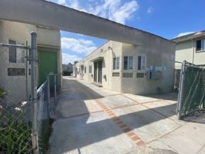 Los Angeles apartment for rent - A long concrete walkway leads to a green door.