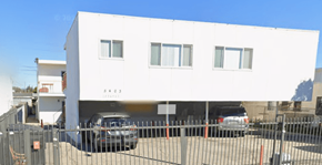 Los Angeles apartment for rent - A white building with a black car parked in front of it.