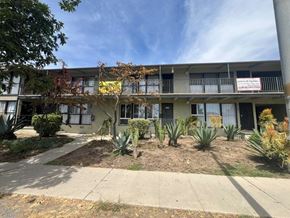 Los Angeles apartment for rent - A building with a sign that says "For Rent" is surrounded by plants.