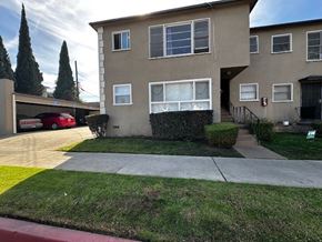 Los Angeles apartment for rent - A beige two-story house with a red car parked in the driveway.