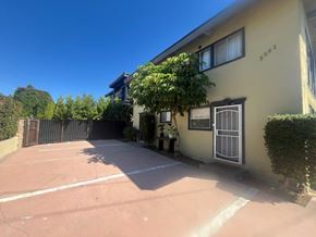 Los Angeles apartment for rent - A yellow house with a black gate and a white door.