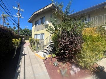 Los Angeles apartment for rent - A residential building with a staircase and greenery in front.