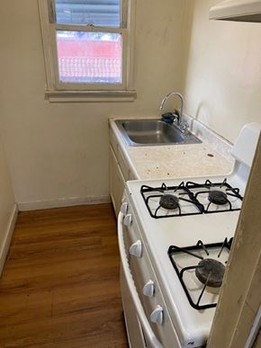 Maywood apartment for rent - A white gas stove with a sink in the corner.