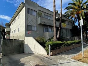 Los Angeles apartment for rent - A concrete building with a palm tree in front.