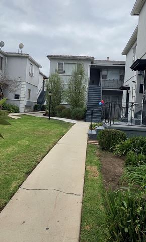 Los Angeles apartment for rent - A concrete pathway leads to a house with a small garden.