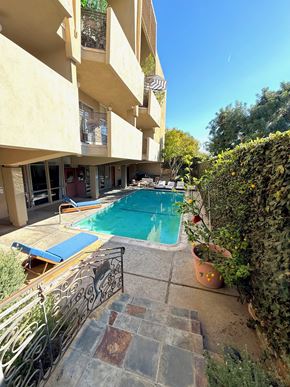 Santa Monica apartment for rent - A small pool in a courtyard surrounded by buildings and plants.