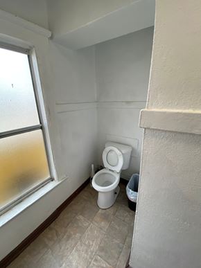 Los Angeles apartment for rent - A white toilet is in a small bathroom next to a window.