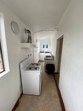 Los Angeles apartment for rent - A white stove is in a narrow hallway.