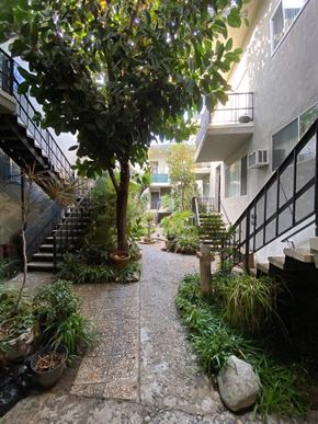 West Hollywood apartment for rent - A pathway with a tree and plants on both sides.