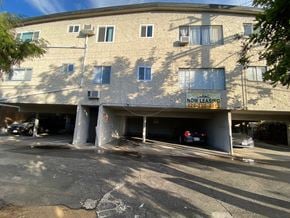 West Hollywood apartment for rent - A building with a sign that says "NOW LEASING" and a phone number.
