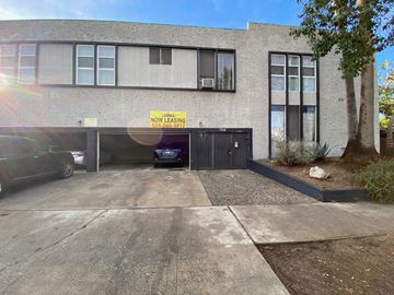 West Hollywood apartment for rent - A building with a sign that says "NOW LEASING" and a phone number below it.