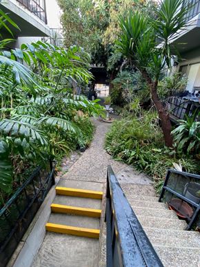 West Hollywood apartment for rent - A staircase with yellow handrails leads up to a building.