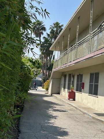 Los Angeles apartment for rent - A building with a balcony and a red object on the ground.