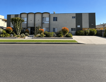 Los Angeles apartment for rent - A modern building with a grey facade and a green lawn in front.