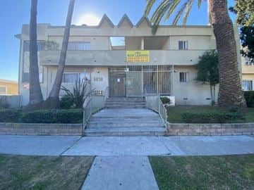 Los Angeles apartment for rent - A building with a "NOW LEASING" sign in front of it.