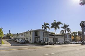 Los Angeles apartment for rent - A sunny day in a residential area with apartment buildings and parked cars.