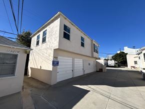 Los Angeles apartment for rent - A two-story house with a garage is situated in a sunny area.