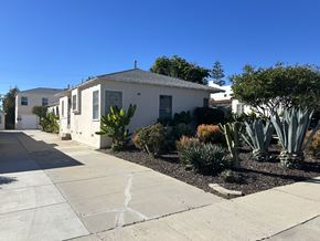 Los Angeles apartment for rent - A white house with a grey roof and a driveway in front.