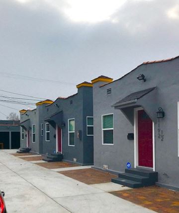 Los Angeles apartment for rent - A series of grey houses with red doors and windows.