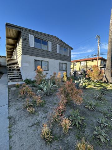 Los Angeles apartment for rent - A house with a grey siding and a brown roof with a staircase leading up to the entrance.