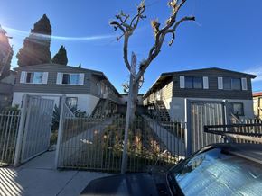Los Angeles apartment for rent - A car is parked in front of a house with a tree in the foreground.