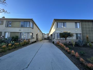 Los Angeles apartment for rent - A long concrete pathway leads between two rows of identical buildings.