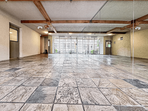 Los Angeles apartment for rent - A large, empty room with marble flooring and wooden beams on the ceiling.