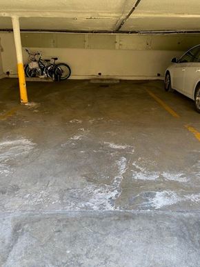 Los Angeles apartment for rent - A white car is parked in a garage next to a bicycle.