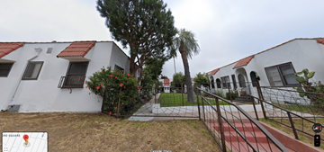 Los Angeles apartment for rent - A white building with a red roof and a tree in front.