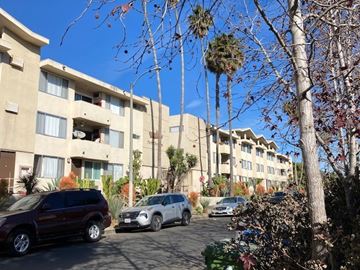Los Angeles apartment for rent - A row of apartment buildings with cars parked in front.