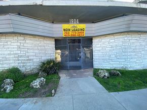 Los Angeles apartment for rent - A building with a sign that says "NOW LEASING" and two phone numbers.