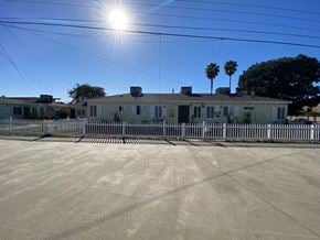 Inglewood apartment for rent - A house with a fence in front of it on a sunny day.