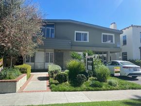 Beverly Hills apartment for rent - A white car is parked in front of a grey house.