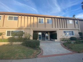 Gardena apartment for rent - A building with a beige facade and a red brick walkway in front.