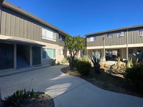 Los Angeles apartment for rent - A sunny day at the courtyard of a building with concrete floors and grey walls.