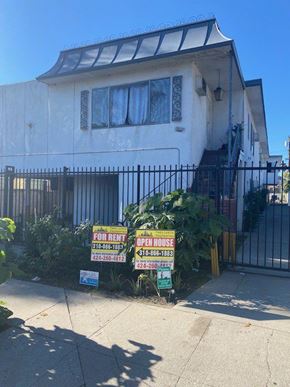 Los Angeles apartment for rent - A white house with a black fence and a sign that says "For Rent".